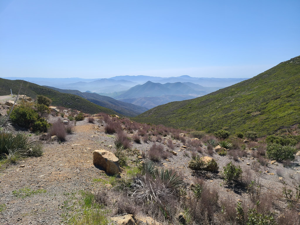 family hiking a trail near San Diego, California with small mountains in background