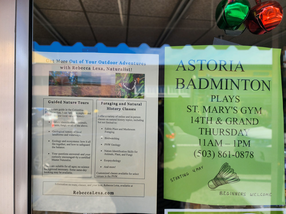 posters of community events in a store window in Astoria, Oregon